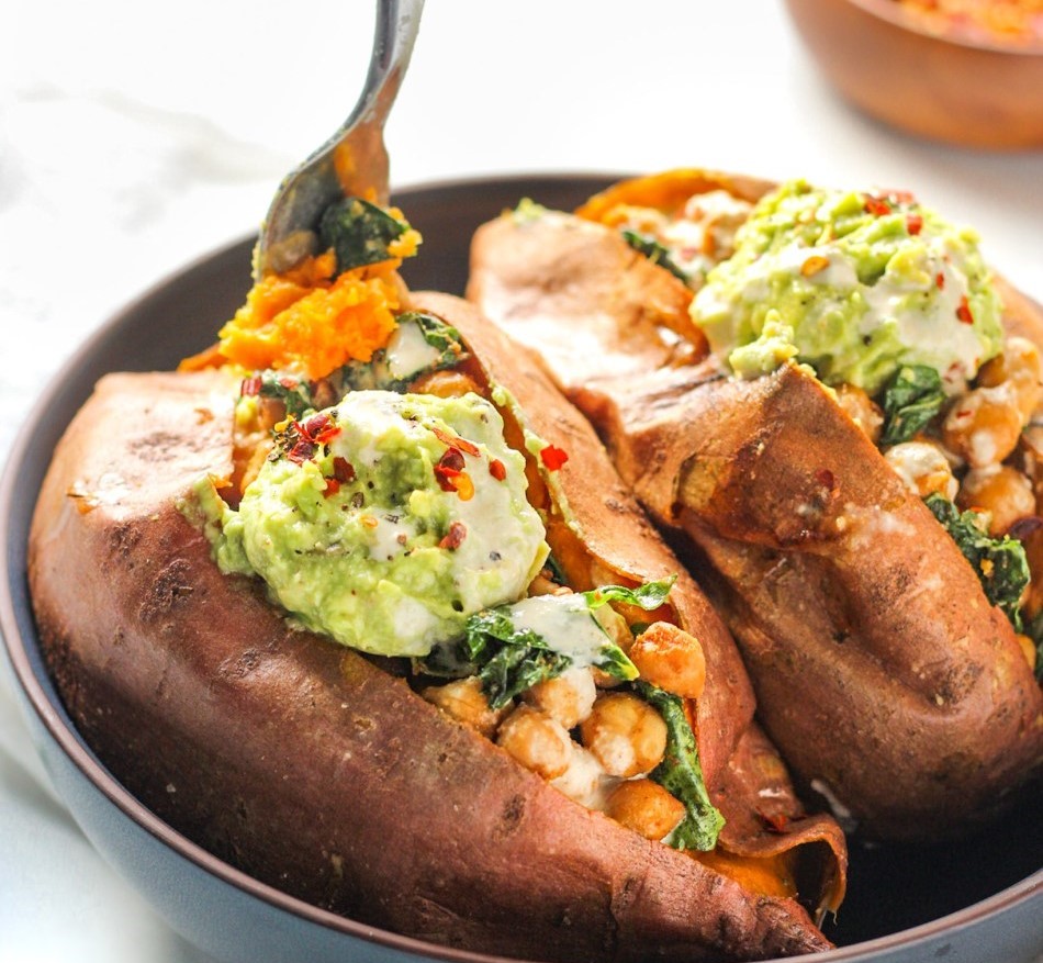 Stuffed sweet potato with spiced roasted chickpeas, spinach and guacamole