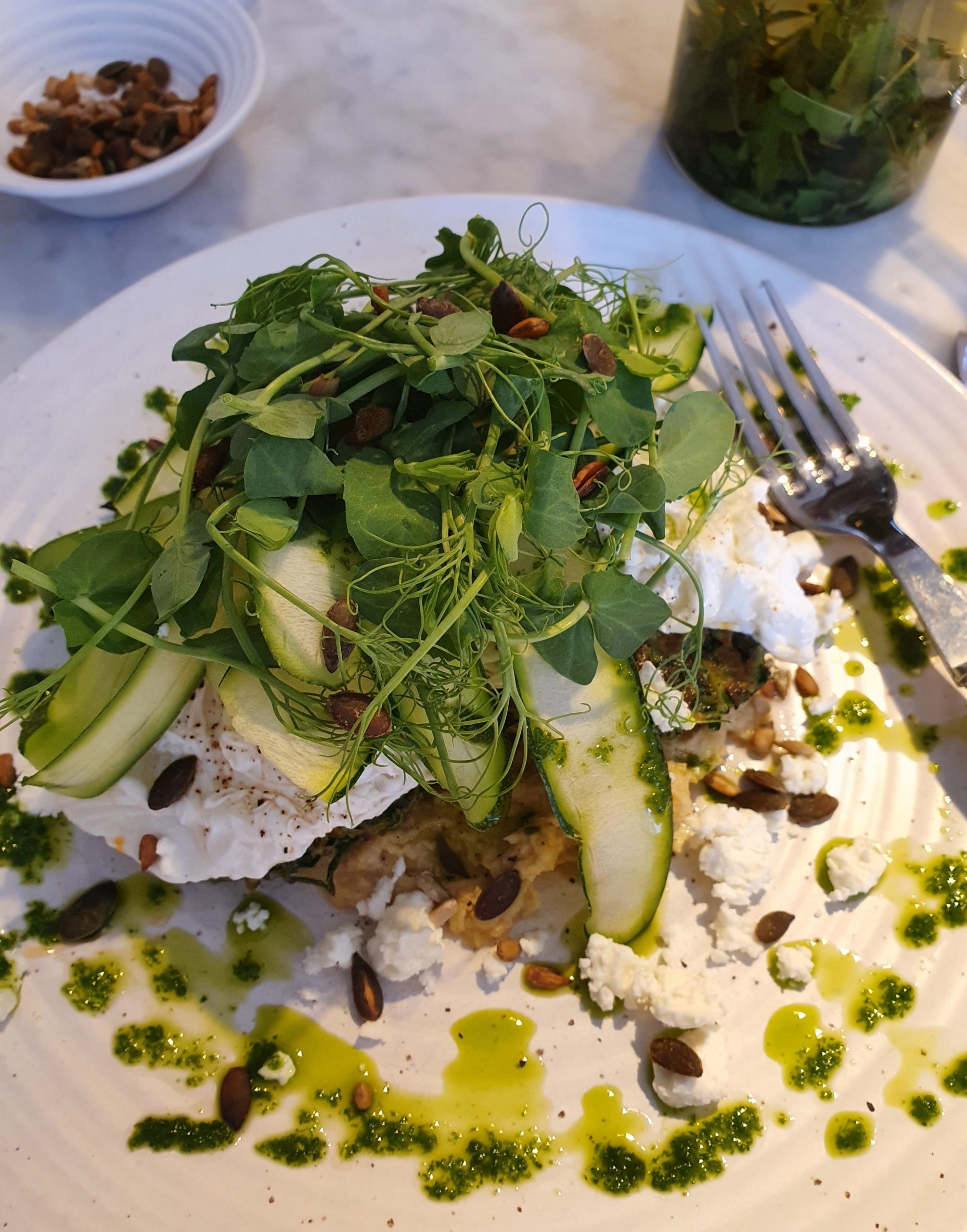 ￼Gluten Free Courgette, Pea, Herb & Feta Fritters With Poached Egg, A Courgette Ribbon Salad, And Toasted Seeds